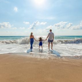 Parents and their child on the beach.