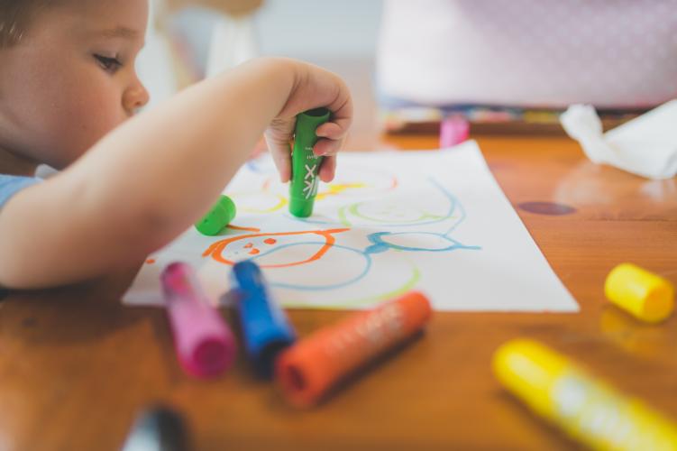A child playing with markers.